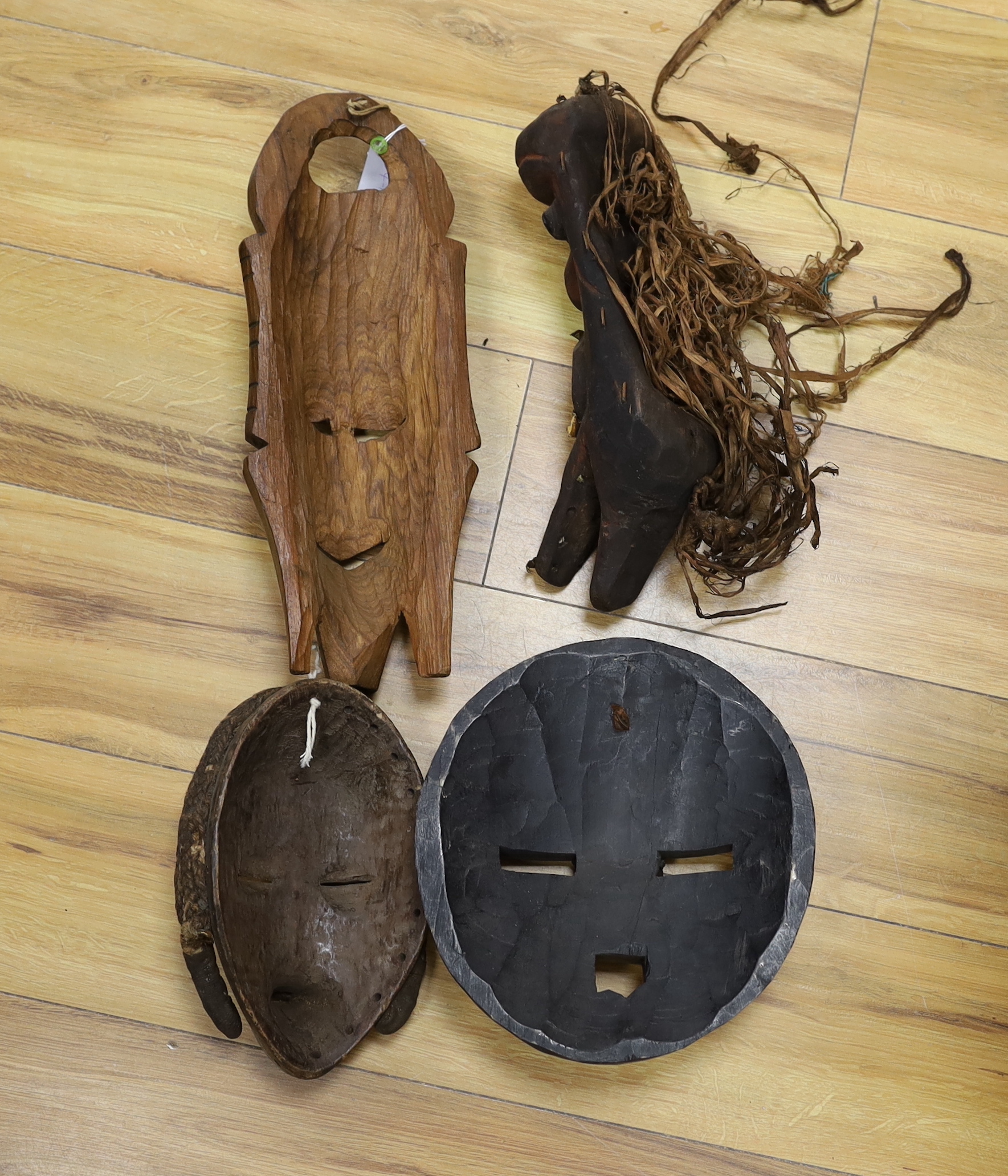 Four African tribal carved wooden masks, tallest 39 cm high